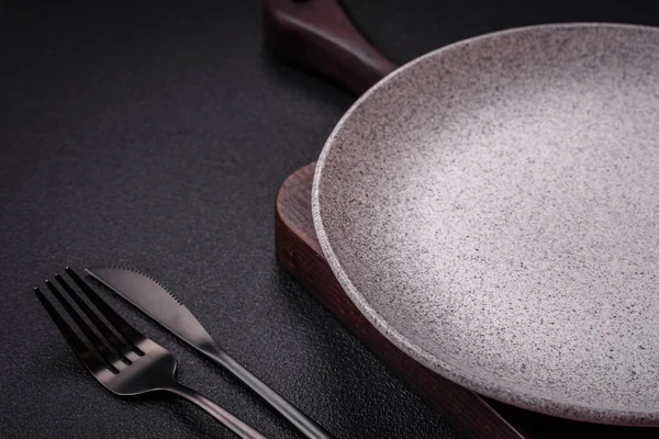 Empty round ceramic plate as an item of kitchen utensils on a textured concrete background