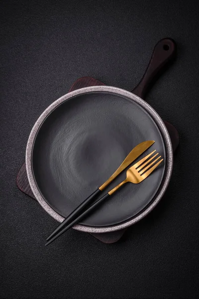 Empty round ceramic plate as an item of kitchen utensils on a textured concrete background