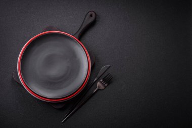 Dökümlü beton zemin üzerinde şişkin boş seramik bir tabak. Mutfak aletleri