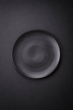 Dökümlü beton zemin üzerinde şişkin boş seramik bir tabak. Mutfak aletleri