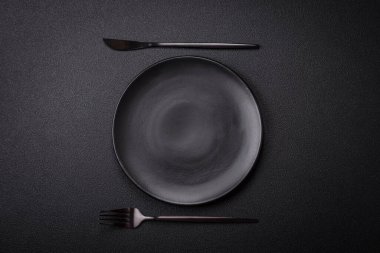 Dökümlü beton zemin üzerinde şişkin boş seramik bir tabak. Mutfak aletleri