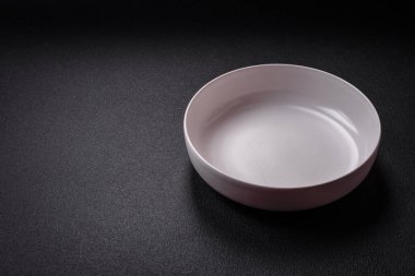 Dökümlü beton zemin üzerinde şişkin boş seramik bir tabak. Mutfak aletleri