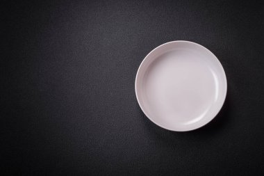 Dökümlü beton zemin üzerinde şişkin boş seramik bir tabak. Mutfak aletleri