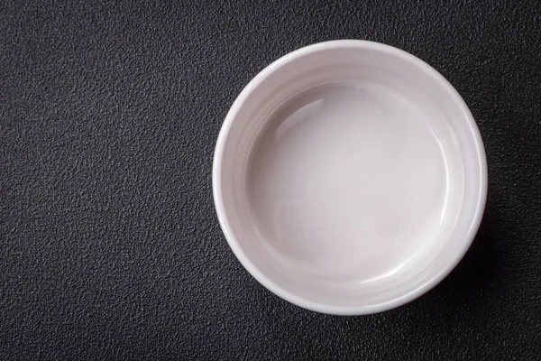 Beautiful empty white ceramic gravy boat on a textured concrete background. Kitchen utensil item