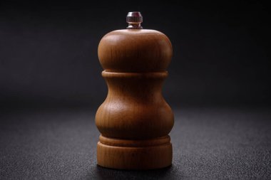 Güzel ahşap şekilli biber ya da koyu dokulu arka planda değirmeni olan tuzluk.