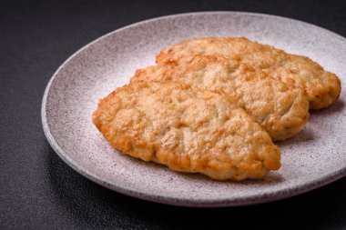 Lezzetli taze kızarmış balık ya da koyu beton arka planda baharat ve otlu tavuk pirzolası.