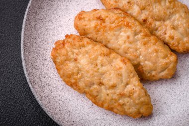 Lezzetli taze kızarmış balık ya da koyu beton arka planda baharat ve otlu tavuk pirzolası.