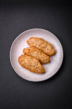 Lezzetli taze kızarmış balık ya da koyu beton arka planda baharat ve otlu tavuk pirzolası.