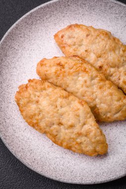 Lezzetli taze kızarmış balık ya da koyu beton arka planda baharat ve otlu tavuk pirzolası.