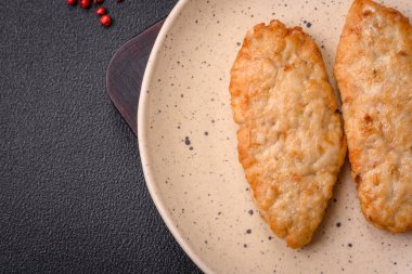 Lezzetli taze kızarmış balık ya da koyu beton arka planda baharat ve otlu tavuk pirzolası.