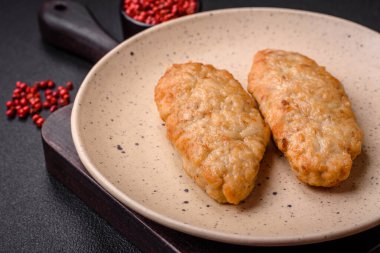 Lezzetli taze kızarmış balık ya da koyu beton arka planda baharat ve otlu tavuk pirzolası.