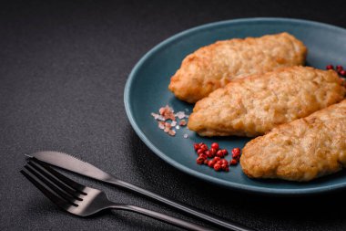 Lezzetli taze kızarmış balık ya da koyu beton arka planda baharat ve otlu tavuk pirzolası.