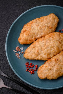 Lezzetli taze kızarmış balık ya da koyu beton arka planda baharat ve otlu tavuk pirzolası.
