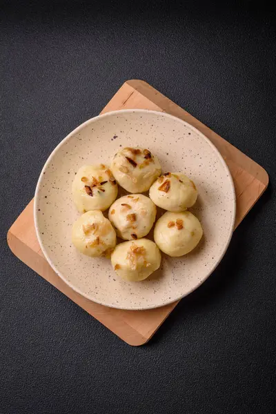 Delicious fresh cooked homemade dumplings with cheese, potatoes and salt on a ceramic plate