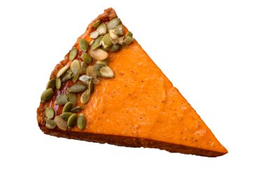 Beautiful tasty pumpkin pie with slices on a black ceramic plate on a dark concrete background