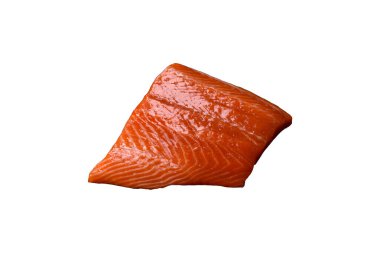 Fillet of raw red salmon fish with salt, spices and herbs on a dark concrete background