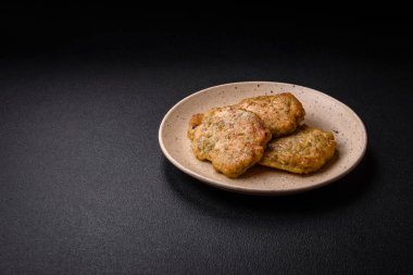 Lezzetli taze kıymalı balık pirzolası. Esmer arka planda baharatlar ve otlarla birlikte.