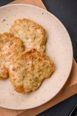 Lezzetli taze kıymalı balık pirzolası. Esmer arka planda baharatlar ve otlarla birlikte.