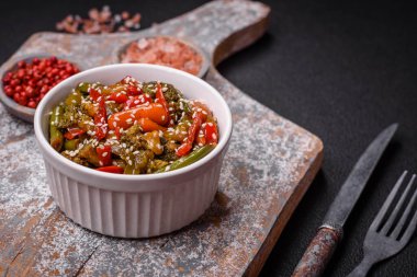 Sebze karışımı mısır, havuç, biber, brokoli, teriyaki soslu soğan koyu beton arka planda seramik bir tabakta