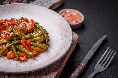 Sebze karışımı mısır, havuç, biber, brokoli, teriyaki soslu soğan koyu beton arka planda seramik bir tabakta