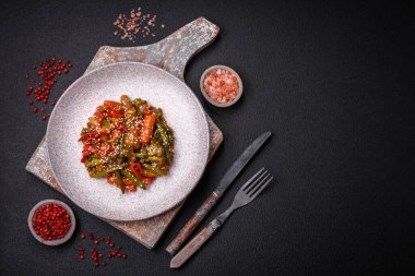 Sebze karışımı mısır, havuç, biber, brokoli, teriyaki soslu soğan koyu beton arka planda seramik bir tabakta