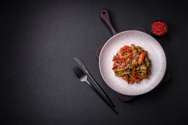 Sebze karışımı mısır, havuç, biber, brokoli, teriyaki soslu soğan koyu beton arka planda seramik bir tabakta