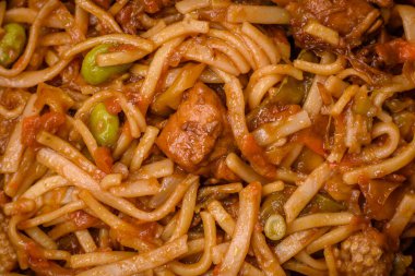 Sebzeli, mantarlı, tuzlu ve baharatlı lezzetli Asya udonu tabağı koyu beton arka planda.