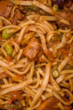 Sebzeli, mantarlı, tuzlu ve baharatlı lezzetli Asya udonu tabağı koyu beton arka planda.