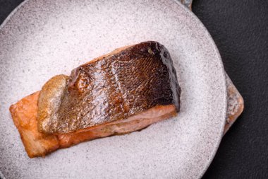 Taze pişirilmiş lezzetli somon bifteği, baharatlar ve ızgarada pişirilmiş otlar. Sağlıklı deniz ürünleri