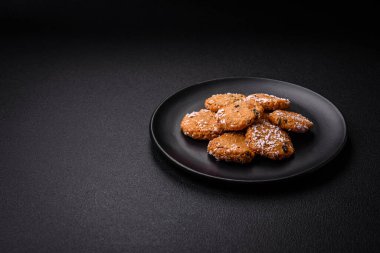 Koyu beton bir zemine serpiştirilmiş hindistan cevizi parçacıkları serpiştirilmiş lezzetli yuvarlak sünger kurabiyeleri.