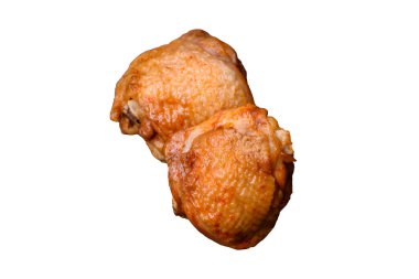 Tuz, baharat ve otlarla pişirilmiş lezzetli sulu tavuk butları koyu beton arka planda seramik bir tabakta.