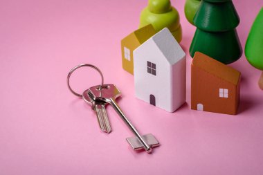 Küçük ahşap bir ev ve anahtarlar kendi evinize yatırım yapmak ve gayrimenkul satın alma hedefine ulaşmak için bir fikir. Fikrin için arka plan