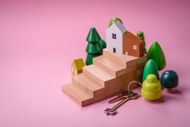 Küçük ahşap bir ev ve anahtarlar kendi evinize yatırım yapmak ve gayrimenkul satın alma hedefine ulaşmak için bir fikir. Fikrin için arka plan