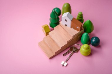 Küçük ahşap bir ev ve anahtarlar kendi evinize yatırım yapmak ve gayrimenkul satın alma hedefine ulaşmak için bir fikir. Fikrin için arka plan