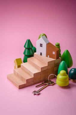 Küçük ahşap bir ev ve anahtarlar kendi evinize yatırım yapmak ve gayrimenkul satın alma hedefine ulaşmak için bir fikir. Fikrin için arka plan