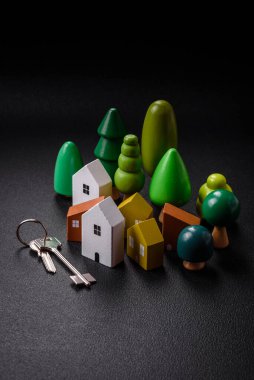 Küçük ahşap bir ev ve anahtarlar kendi evinize yatırım yapmak ve gayrimenkul satın alma hedefine ulaşmak için bir fikir. Fikrin için arka plan