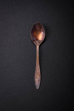 Empty metal spoon on dark textured concrete background. Cutlery, preparation for dinner