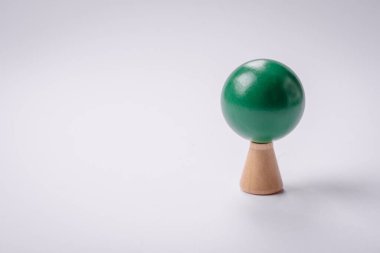 Beyaz arka planda yeşil taç ve gövdesi olan tahta bir ağaç modeli. Ahşap oyuncaklarla çocuk büyümesi