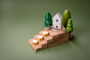 Küçük ahşap bir ev ve anahtarlar kendi evinize yatırım yapmak ve gayrimenkul satın alma hedefine ulaşmak için bir fikir. Fikrin için arka plan