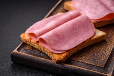 Tost ekmekli, jambonlu, domatesli, tuzlu ve baharatlı lezzetli sandviç.