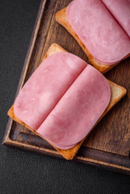 Tost ekmekli, jambonlu, domatesli, tuzlu ve baharatlı lezzetli sandviç.