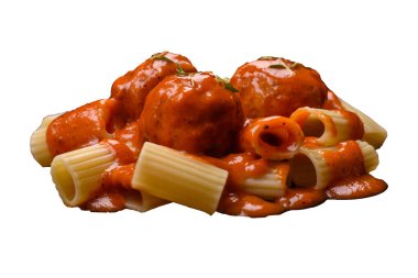 Lezzetli taze köfteler, tuz, baharat ve çimento arkaplanda bitkilerle birlikte domates sosu.