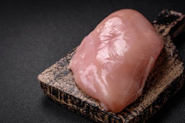 Koyu beton bir masada baharat ve otlarla taze tavuk filetosu. Et yemekleri için hazırlık.