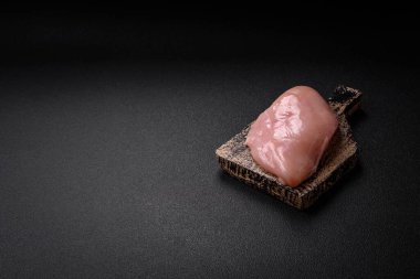 Koyu beton bir masada baharat ve otlarla taze tavuk filetosu. Et yemekleri için hazırlık.