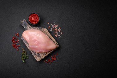 Koyu beton bir masada baharat ve otlarla taze tavuk filetosu. Et yemekleri için hazırlık.