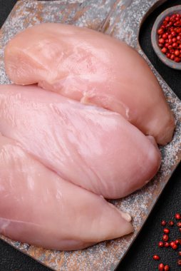 Koyu beton bir masada baharat ve otlarla taze tavuk filetosu. Et yemekleri için hazırlık.