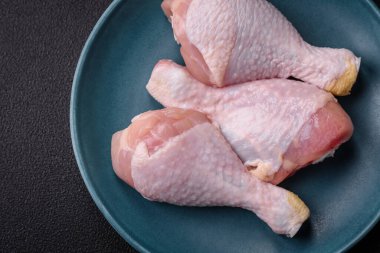 Tuzlu, baharatlı ve çimento kaplı çiğ tavuk bacakları. Evde yemek pişirmek.