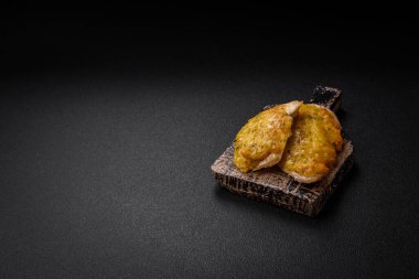 Dijon hardalıyla kızartılmış lezzetli et. Tuz, baharat ve otlarla birlikte koyu beton bir arka planda.