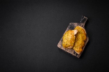 Dijon hardalıyla kızartılmış lezzetli et. Tuz, baharat ve otlarla birlikte koyu beton bir arka planda.