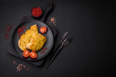 Dijon hardalıyla kızartılmış lezzetli et. Tuz, baharat ve otlarla birlikte koyu beton bir arka planda.